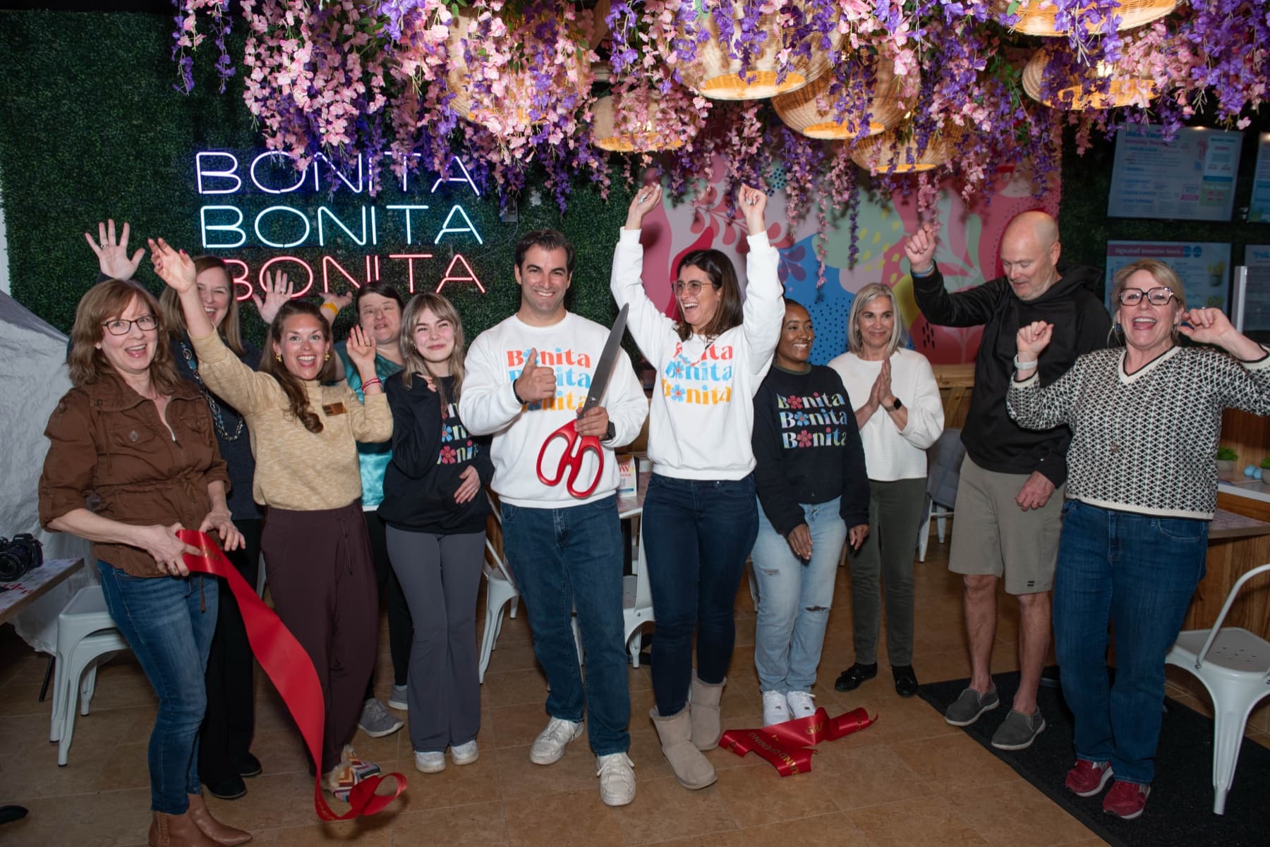 Kyle Kissane cutting the ribbon at a Bonita Bowls grand opening, surrounded by family and team